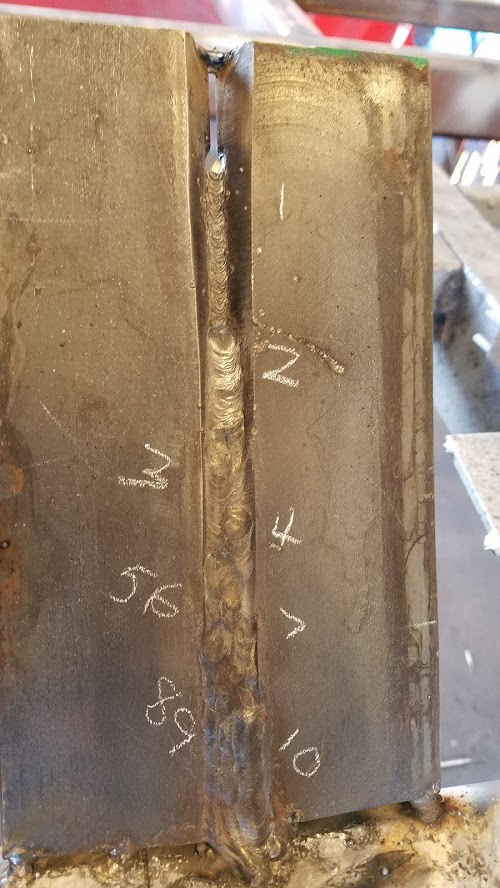 Finished 1-inch groove test plate with the ten weld passes numbered in chalk
